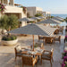 Midtown Bamboo umbrellas with striped Sunbrella canopies over a restaurant terrace